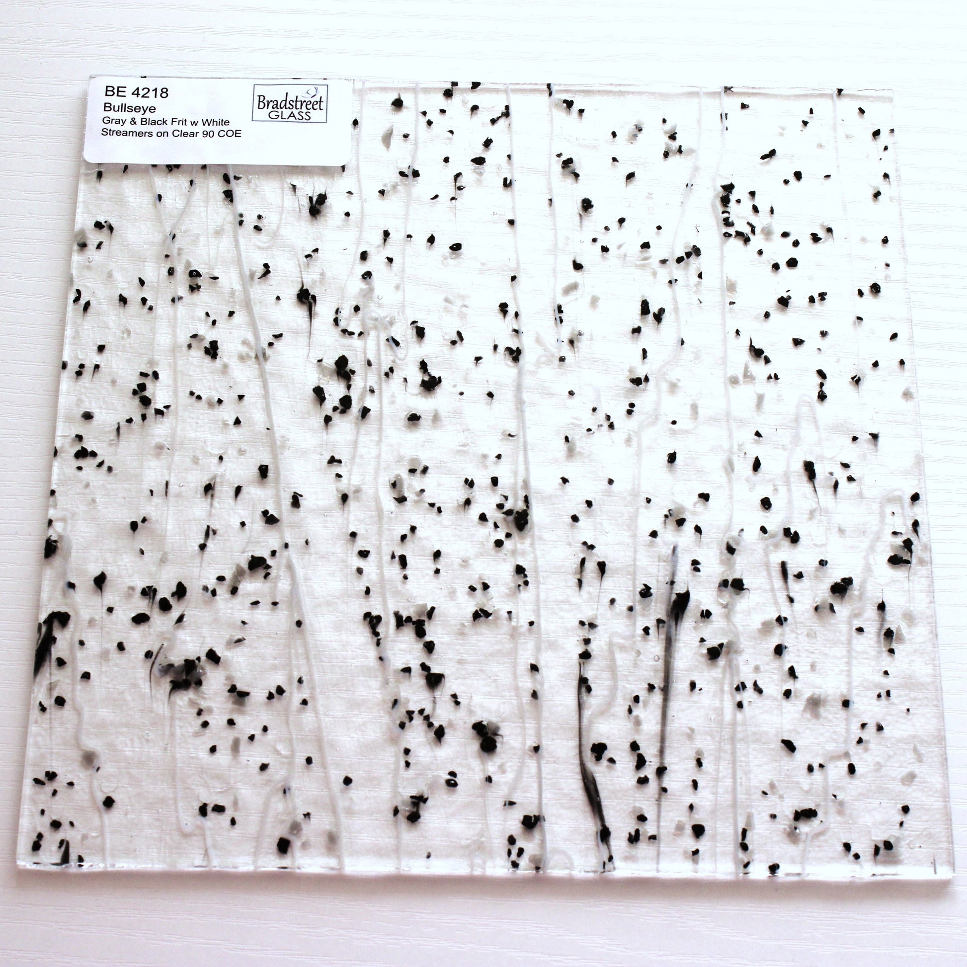 Gray & Black Frit, White Streamers on Clear Stained Glass Sheet. Bullseye 4218 Fusible 90 COE Fusible stringer glass, fusible frit glass.  Bradstreet Glass