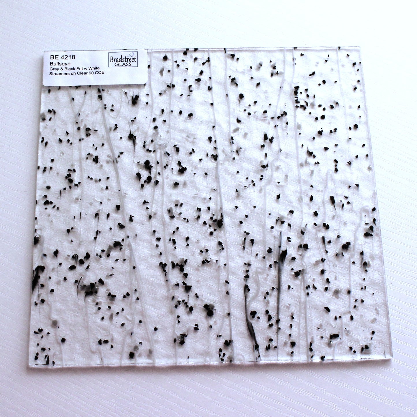 Gray & Black Frit, White Streamers on Clear Stained Glass Sheet. Bullseye 4218 Fusible 90 COE Fusible stringer glass, fusible frit glass.  Bradstreet Glass