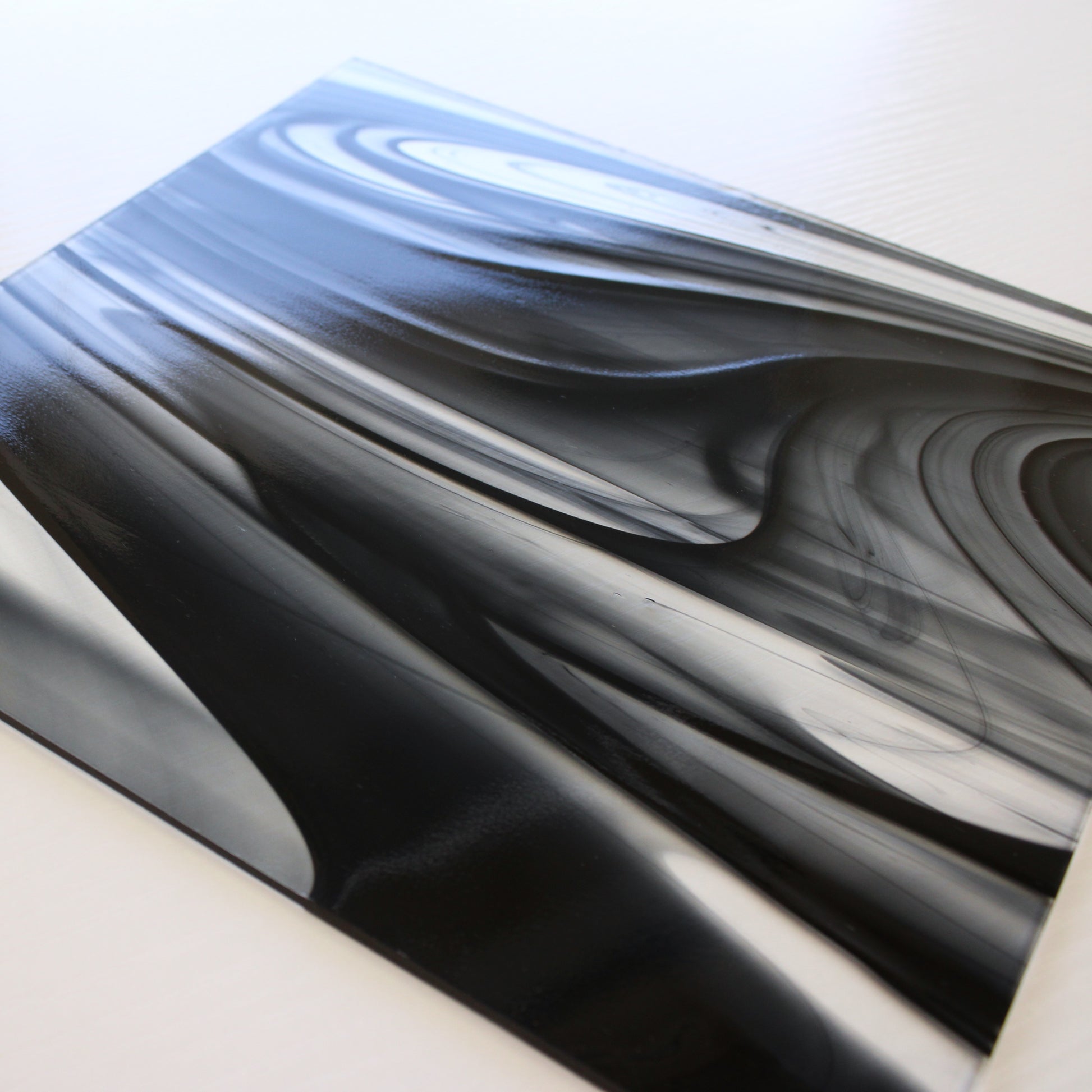 Close-up Oceanside BR400 black and clear baroque stained glass sheet showing bold irregular mixture with high-contrast pattern. Bradstreet Glass