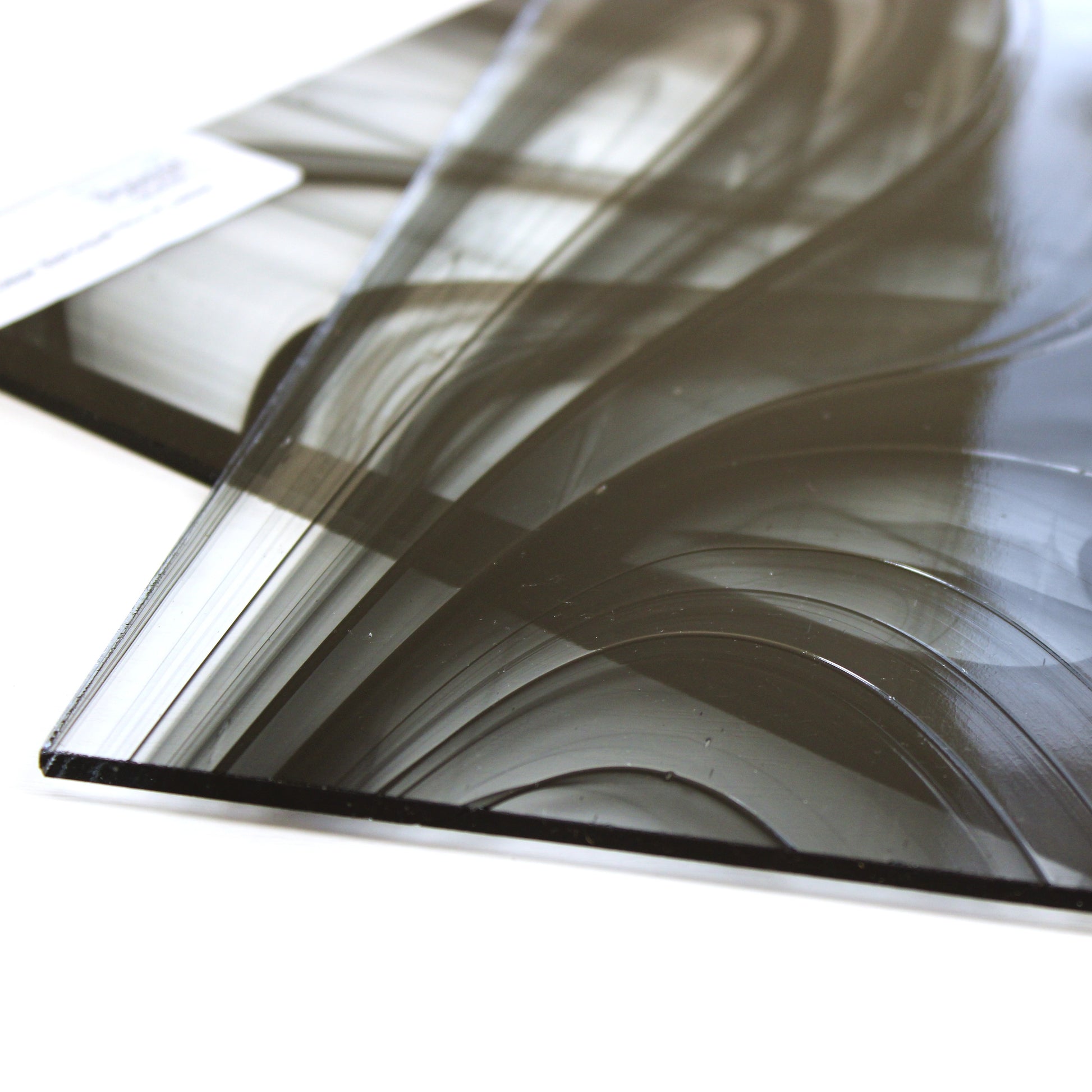 Close-up Oceanside BR400 black and clear baroque stained glass sheet showing bold irregular mixture with high-contrast pattern. Bradstreet Glass