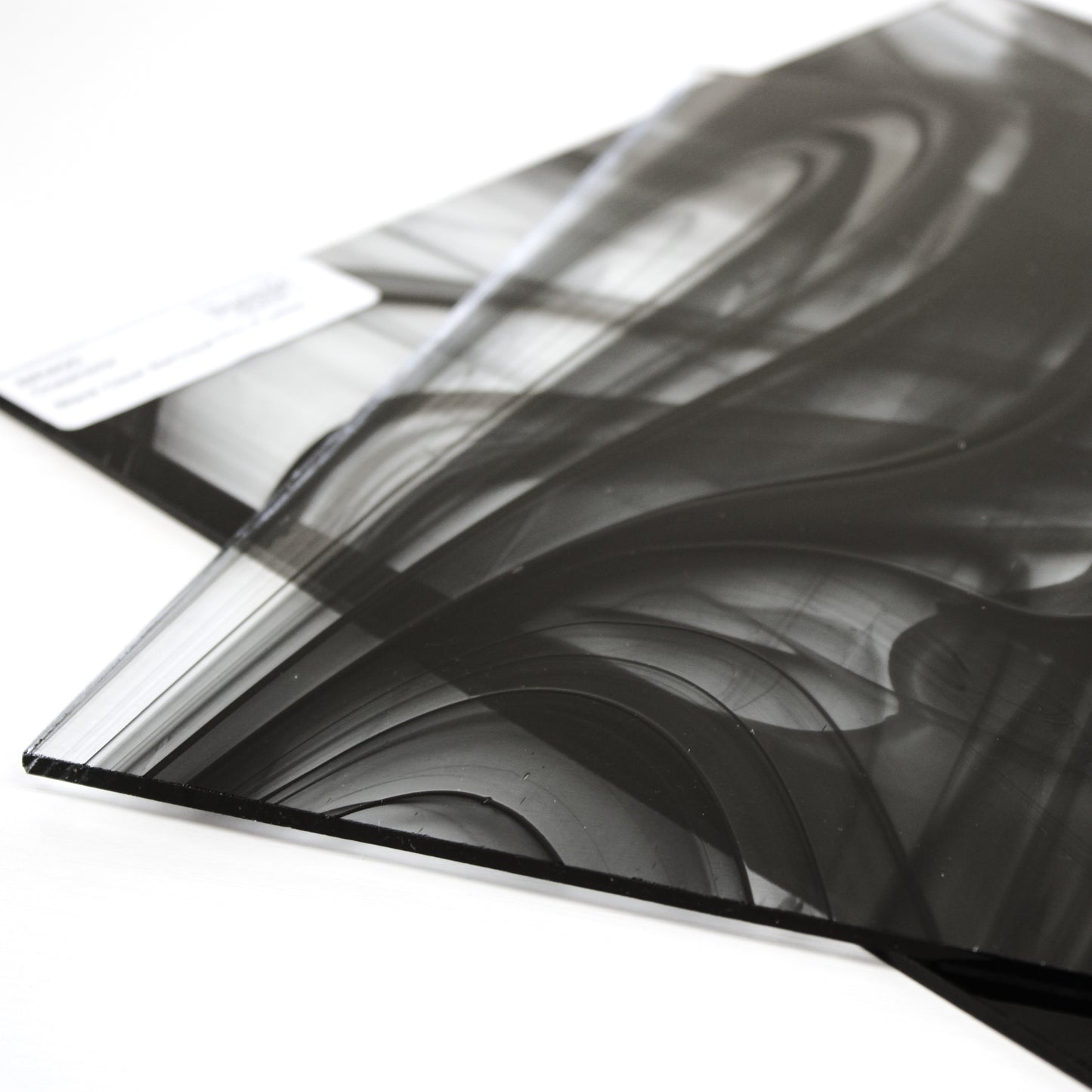 Close-up Oceanside BR400 black and clear baroque stained glass sheet showing bold irregular mixture with high-contrast pattern. Bradstreet Glass