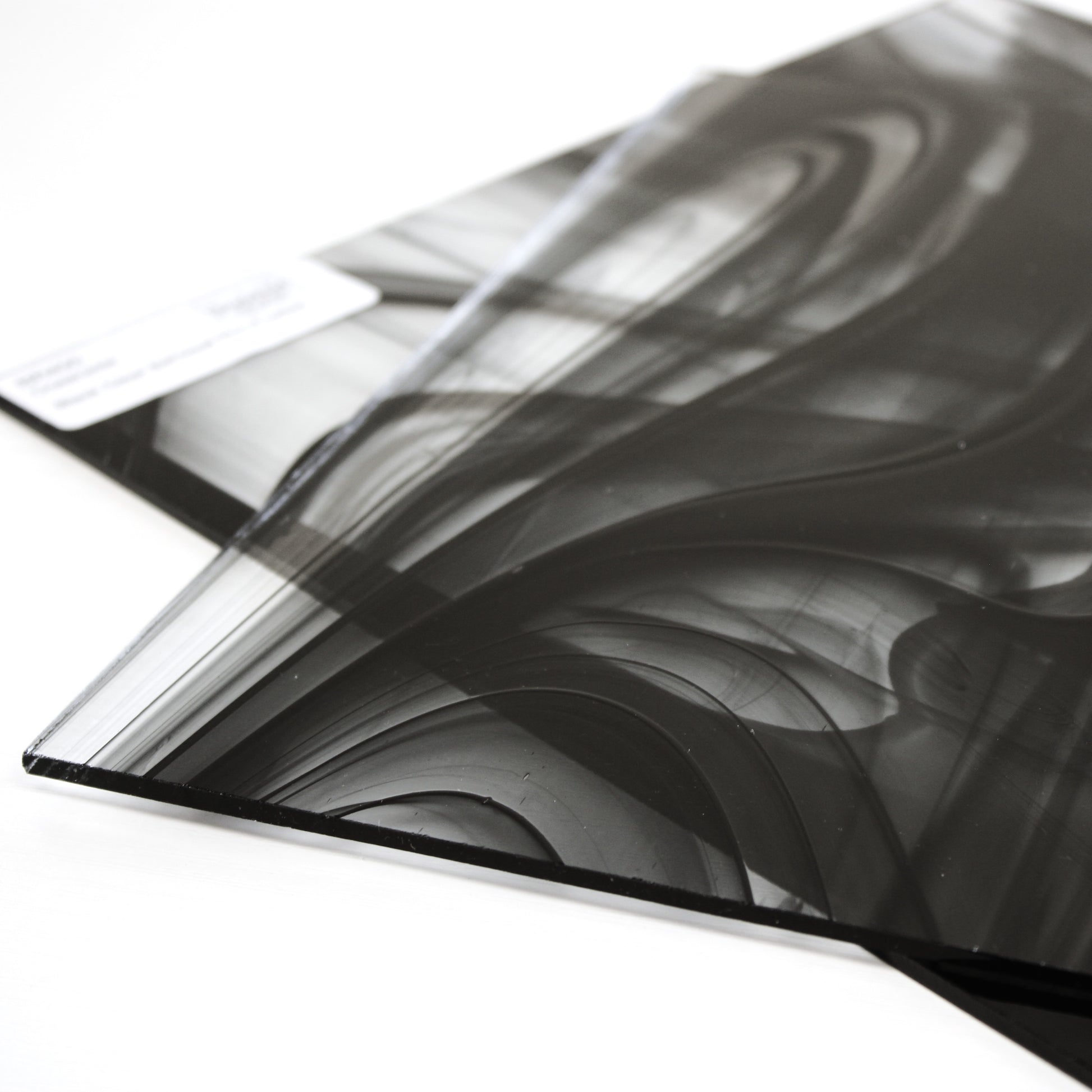 Close-up Oceanside BR400 black and clear baroque stained glass sheet showing bold irregular mixture with high-contrast pattern. Bradstreet Glass